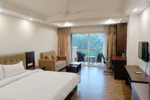 Spacious resort suite featuring a comfortable king-size bed, sofa seating, and private balcony ideal for a staycation with family.